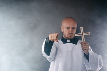 Catholic priest exorcist in white surplice and black shirt - obrazy, fototapety, plakaty