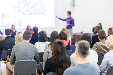 Business and entrepreneurship symposium. Speaker giving a talk at business meeting. Audience in...