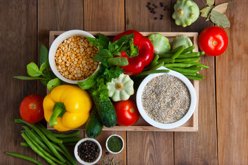 Health food with high fibre. Dietting, whole wheat cerals, grains, vegetables, antioxidants and vitamins: zzuchini, tomatoes, cucumbers, beans. Rustic wooden background top view.