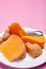 Pieces of native French aged cheese Mimolette, produced in Lille with greyish curst made by special cheese mites