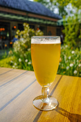 Two cold light unfiltered beer in glasses served on sunny outdoor terrace in garden
