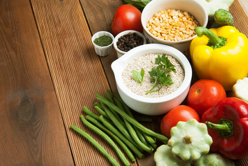 Health food with high fibre. Dietting, whole wheat cerals, grains, vegetables, antioxidants and vitamins: zzuchini, tomatoes, cucumbers, beans. Rustic wooden background top view.