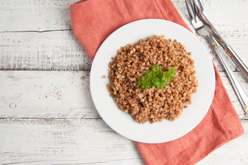 Cooked buckwheat on white wooden background. Healthy food.