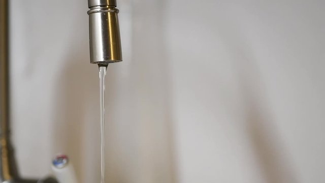 Wasser l&auml;uft aus einem Wasserhahn 