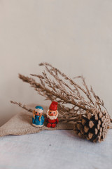 New Year, Santa Claus (Father Frost) and Snow Maiden, Christmas card. Plasticine figurines on a textile linen surface. Cone and dry flower like decoration.