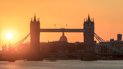 Sunset behind Tower Bridge, London, UK. Behind can be seen the dome of St Paul's Cathedral