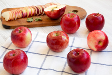 Raw red apples over white wooden background, side view. Closeup.