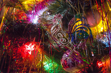 Obraz na płótnie Canvas Christmas toys on christmas tree with luminous festoon closeup. New Year's holiday background.