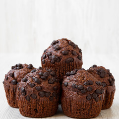 Homemade chocolate cupcakes on white wooden background, side view. Closeup.