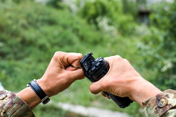male hands holding a hand grenade for airsoft
