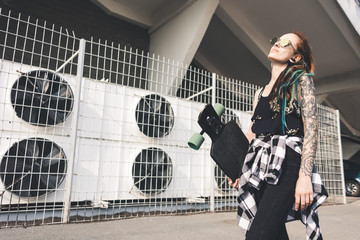 young girl with tattoo and dreadlocks on urban industrial background