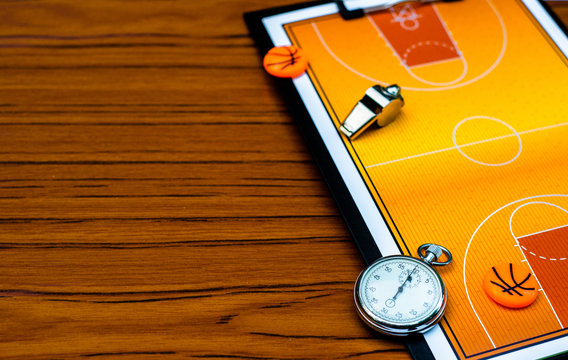 Clipboard With Basketball Field, Coach Whistle And Stopwatch On Wood Background. Close Up Sport Mockup Template.