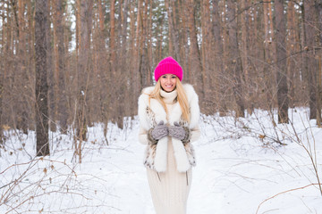 Fototapeta premium Fashion and people concept - Lovely young woman in warm jacket in winter park