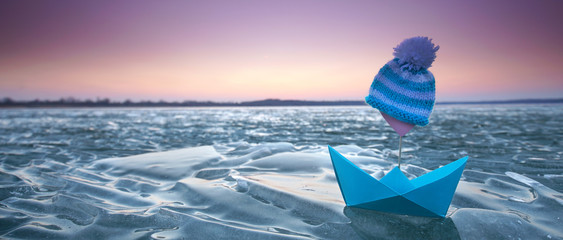 Eisschollen und Papierboot am See