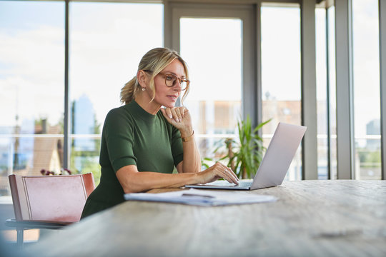 Mature woman using laptop on table at home