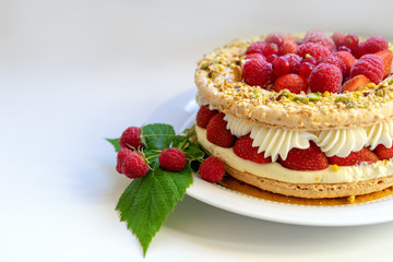 Delicious home made cake with fresh strawberries and rasberries on the white background. Isolated