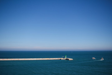 Breakwater in port with two boats in the background