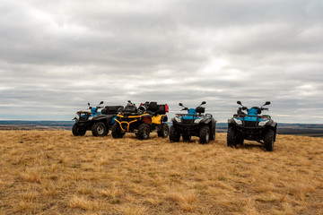 Bright ATVs in the mud are in the field cloudy day, extreme