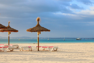 Empty deck chairs and umbrellas on the beach in Port de Alcudia