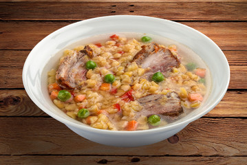 Pea soup with pork ribs. On a wooden background