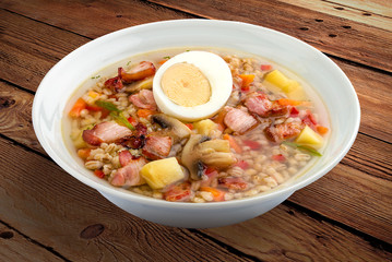Pearl soup with bacon and egg. On a wooden background