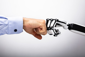 Human Hand And Robot Making Fist Bump - obrazy, fototapety, plakaty