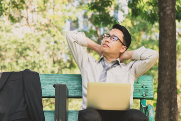 Asian businessman feeling stress outdoor in park