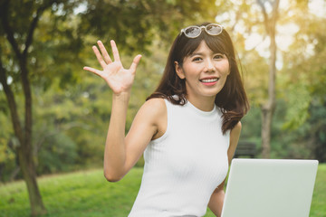 Asian woman say hi / hello with friend