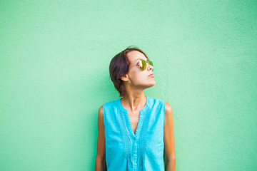 Fototapeta premium Woman in a dress on a wall background.