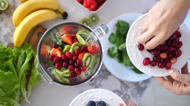 Healthy Eating, Cooking, Vegan Vegetarian Food, Dieting And People Concept. Women Preparing Mixed Berries Smoothie.