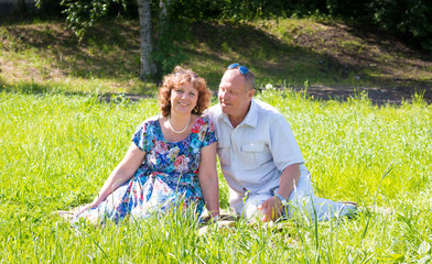man and woman sit on the grass