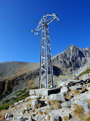 Konstrukcja wsporcza do prowadzenia przewodów linii napowietrznych, słup elektroenergetyczny w wysokich górach, Wysokich Tatrach na Słowacji  - obrazy, fototapety, plakaty