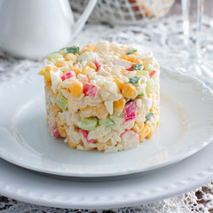 Crab salad with corn laid out on a white plate for portions, square