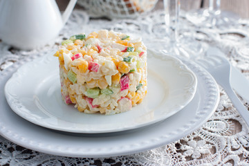 Crab salad with corn, laid out on a white plate for portion serving in a festive table setting, horizontal