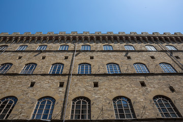 Looking up at a building in Florence with a crenellated roof line; Florence, Tuscany, Italy