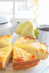 Pie from curd pastry with pear and sour cream, cut into pieces, selective focus