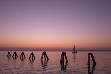 Colorful sunset with pier over lake Neusiedler in Podersdorf am See, Austria, Burgenland