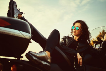 Obraz na płótnie Canvas Young woman resting sitting on a motorcycle . Travel and tourism concept
