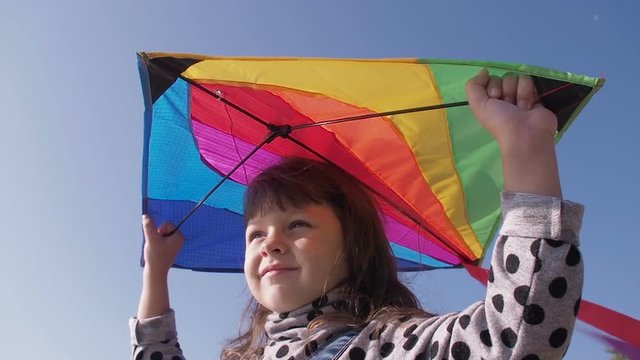 A child with a kite. A girl playing with a kite against the sky.