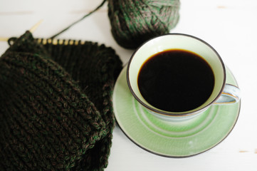 Cup of coffee with warm knitting
