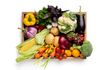 Fresh organic vegetables in wooden box on white