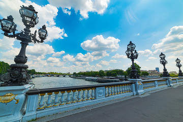 Fototapeta na wymiar Lamp posts in Alexander III bridge under a cloudy sky