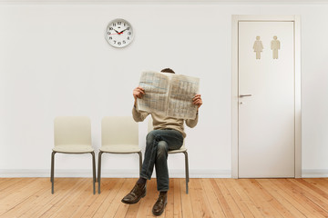 waiting room with a seated person reading newspaper