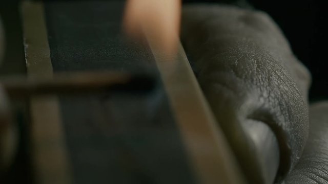 A macro shot of burning match over black background.