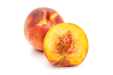Half of peach with whole peach on white.