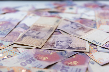 Argentinian one hundred pesos bill money scattered on a table