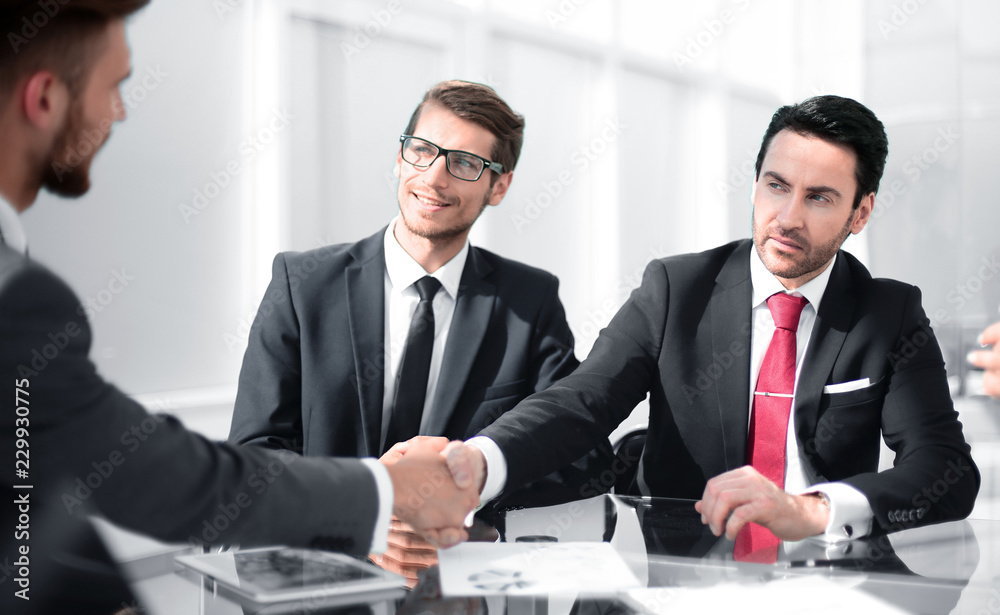 Wall mural handshake business partners at the desk.