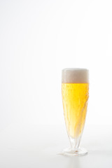Full glass of beer set against a white background