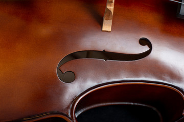  Close up of a cello and a bow set against a black background
