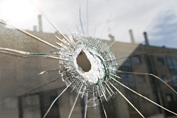 Vandalism or violence concept. Broken glass with hole